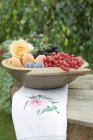 Frutas y bayas en cuenco de madera - foto de stock