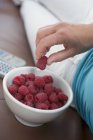 Woman eating fresh raspberries — Stock Photo