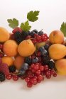 Свежие абрикосы с ягодами и листьями — стоковое фото