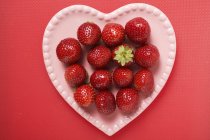 Erdbeeren auf rosa herzförmigem Teller — Stockfoto