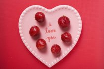 Strawberries on pink heart-shaped plate — Stock Photo