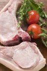 Raw pork chops with fresh herbs — Stock Photo