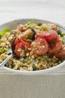 Emmer la salade de blé avec des tomates et des herbes dans une assiette blanche avec cuillère — Photo de stock
