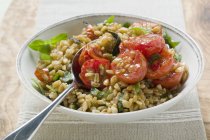 Emmer wheat salad with tomatoes and herbs in white plate with spoon — Stock Photo