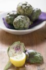 Alcachofas frescas y rodajas de limón - foto de stock