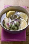 Alcachofas en agua de limón - foto de stock