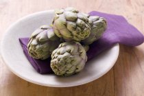 Alcachofas frescas en plato - foto de stock