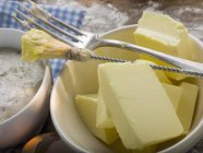 Vista de primer plano de la mantequilla con levadura, cepillo de pastelería y tenedor - foto de stock
