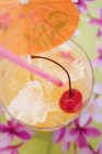 Closeup top view of fruity cocktail with ice cubes and cocktail cherry — Stock Photo