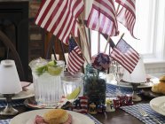 Mesa com pastelaria, bebidas e bandeiras americanas — Fotografia de Stock