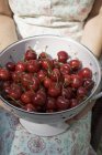 Donna che tiene colabrodo di ciliegie — Foto stock