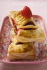 Vue rapprochée des pâtisseries feuilletées avec garniture framboise sur plat à motifs — Photo de stock