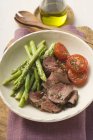Carne bovina con asparagi verdi e pomodori — Foto stock