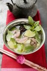 Hühner- und Zitronengrassuppe mit Limette, Thai-Basilikum in Schüssel über Handtuch mit Essstäbchen — Stockfoto