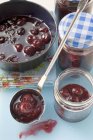 Ladling cherry jam — Stock Photo