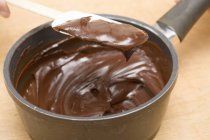 Розтоплений шоколад на шпажці і в сковороді — стокове фото