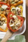 Paprika gefüllt mit Weißbrot, Oliven, Zwiebeln auf weißem Teller und hölzernem Server — Stockfoto