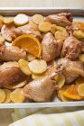 Pedaços de frango não cozidos com laranjas — Fotografia de Stock