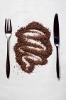 Крупный план тертого шоколада между ножом и вилкой — стоковое фото