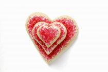 Galletas en forma de corazón con azúcar roja - foto de stock