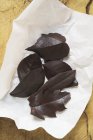 Chocolate leaves on paper — Stock Photo