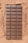 Tafel dunkle Schokolade auf Kakaopulver — Stockfoto