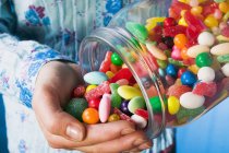 Person tipping sweets — Stock Photo