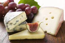 Cheese board with fig and grapes — Stock Photo