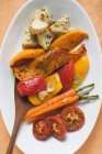 Жареные овощи на белой тарелке с деревянной ложкой — стоковое фото