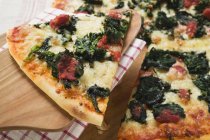 Pizza mit Scheibe auf Server — Stockfoto