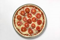 Pizza unbaked over white — Stock Photo