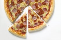 Pizza teilweise aufgeschnitten — Stockfoto