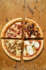 Morceaux de quatre pizzas — Photo de stock
