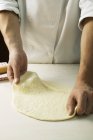 Chef stretching pizza dough — Stock Photo