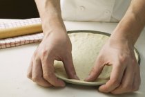 Chef pressing pizza dough — Stock Photo