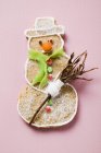 Vista close-up de um biscoito de boneco de neve temperado na superfície rosa — Fotografia de Stock