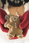 Hands holding gingerbread men — Stock Photo