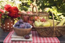 Plums in bowl with pears and apples — Stock Photo