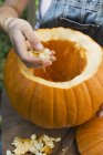 Woman hollowing out pumpkin — Stock Photo