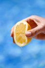 Female hand squeezing lemon — Stock Photo