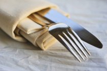 Closeup view of fabric serviette with knife and fork — Stock Photo