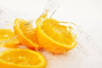 Fatias de laranja com salpicos de água — Fotografia de Stock