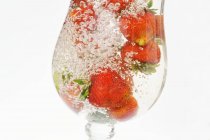 Strawberries in glass of water — Stock Photo