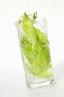 Peas in pods in glass of water — Stock Photo