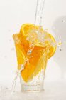 Wasser spritzt auf Orangen im Glas — Stockfoto
