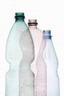 Vue rapprochée de trois bouteilles en plastique ouvertes sur fond blanc — Photo de stock