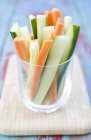 Vegetable sticks in a glass over desk — Stock Photo