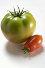 Green beefsteak and plum tomatoes — Stock Photo