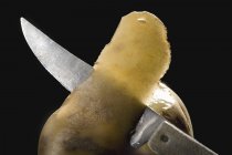 Очистка свежей картошки ножом — стоковое фото