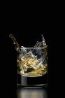 Glass of whisky with ice cube — Stock Photo